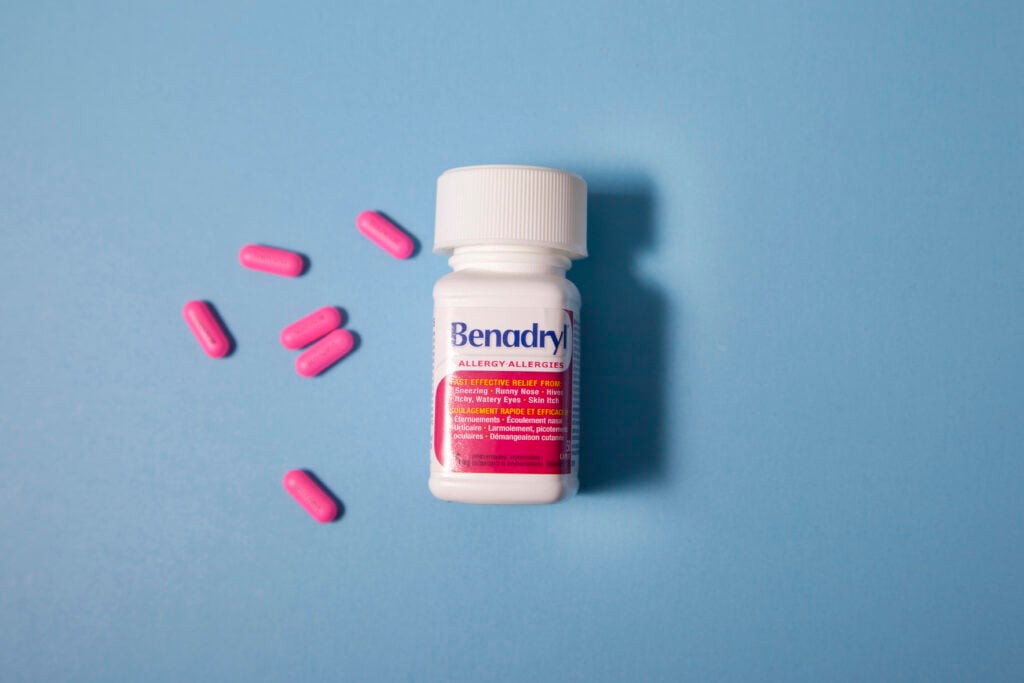 Bottle of Benadryl antihistamine against blue background