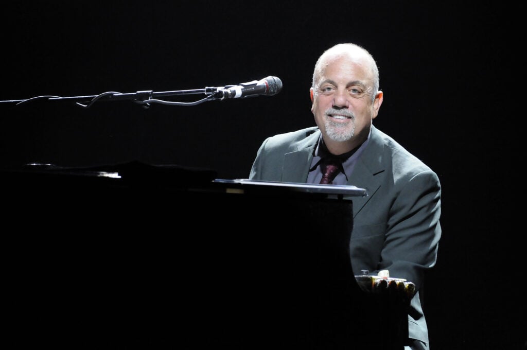 A portrait shot of Singer, songwriter, pianist, legend Billy Joel  performing live at the Honda Center in Anaheim, California with black background