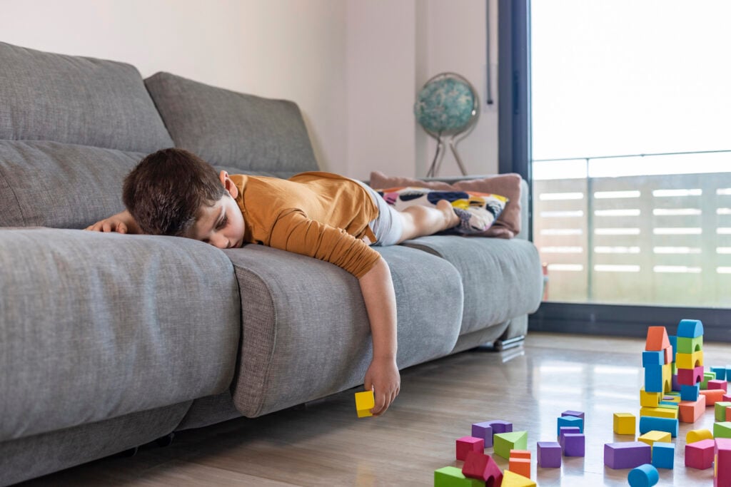 Bored child playing with blocks at home