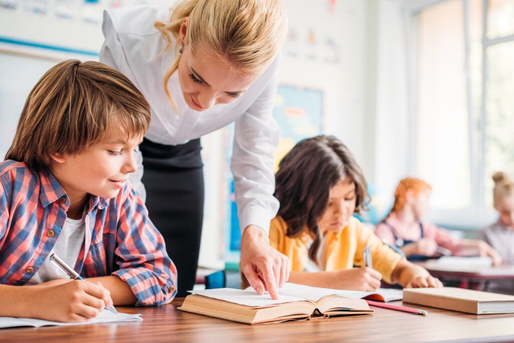 teacher helping schoolboy with exercise