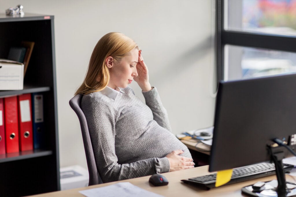 pregnant businesswoman feeling sick at office work