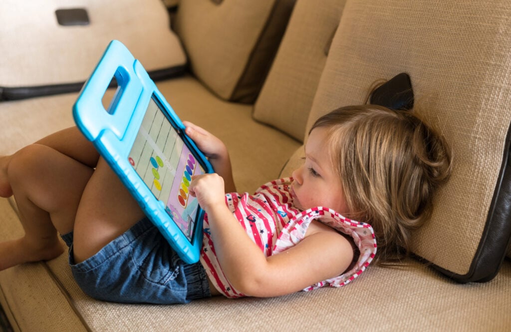 Preschool girl using a tablet computer at home