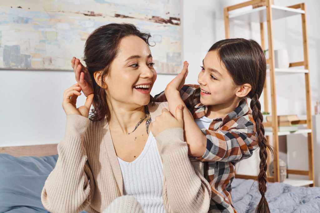 A mother tenderly looks at her daughter, creating a peaceful and heartwarming moment at home.