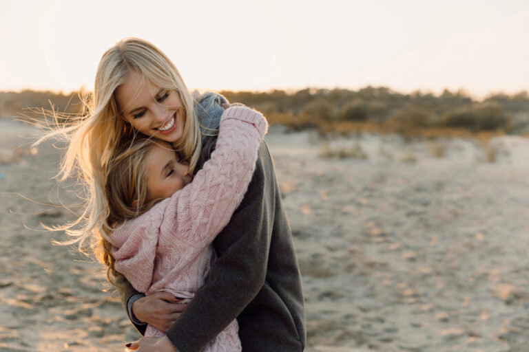 Mother and daughter hugging on the beach