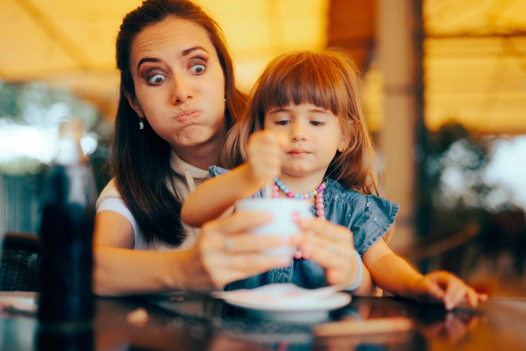 Naughty Girl Stirring the Coffee in a Family Restaurant