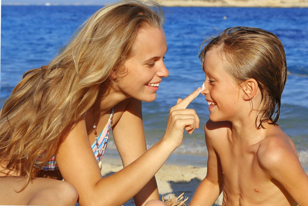 Sun care, mother putting suncream on child