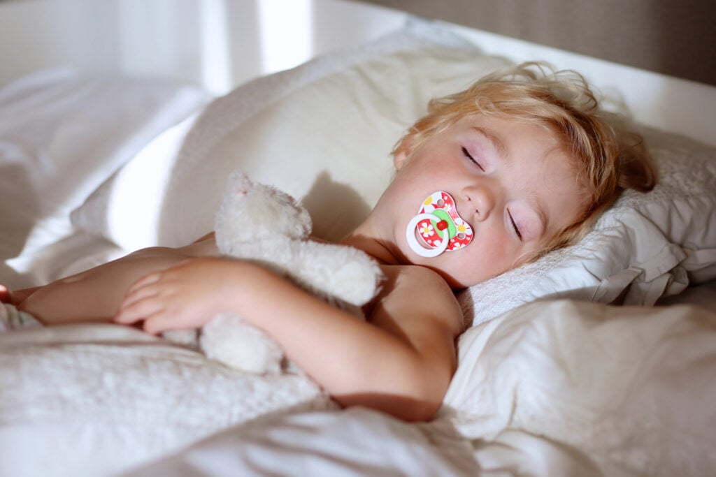 Sweet toddler child sleeping in bed