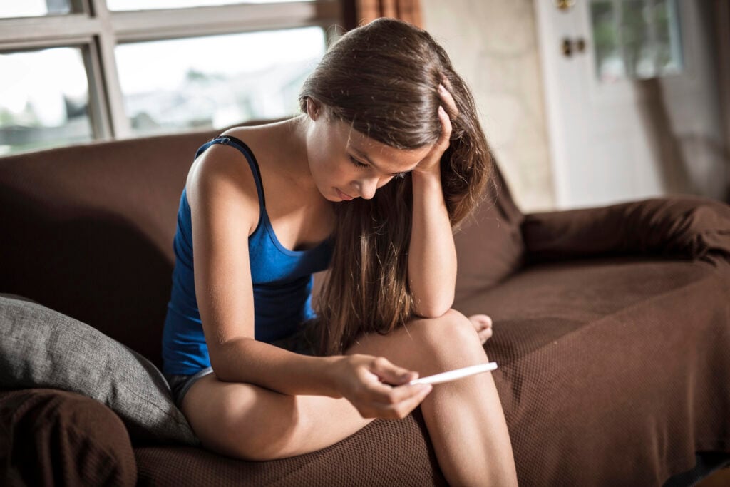 young pregnant woman unhappy with the test that he wants to have an abortion