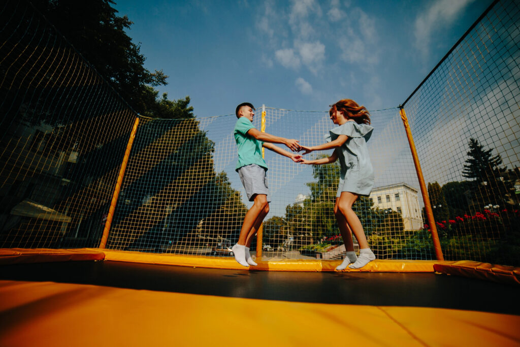 Couple jumping on trampoline in the park