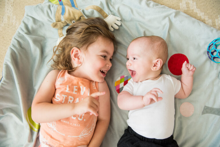 Overhead images of siblings playing on playmat