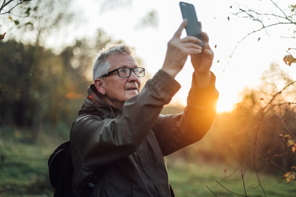 Senior man doing selfie in sunset.