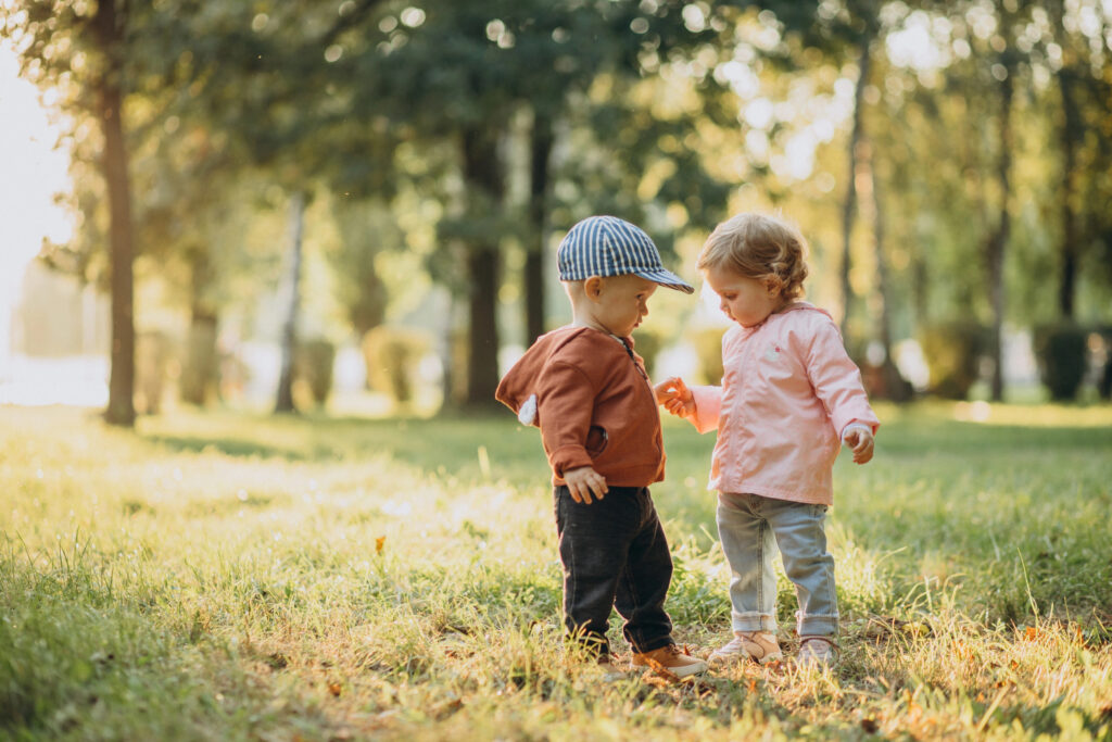 Cute little boy and girl together in autumnal park