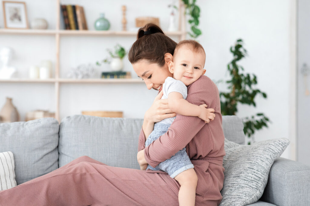 Bonding With Baby. Loving Mom Cuddling Her Adorable Toddler Son At Home