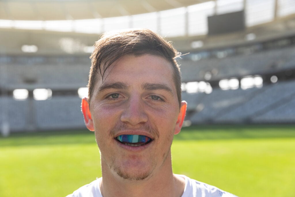 Portrait close up of Caucasian male rugby player with mouth guard in stadium on sunny day.