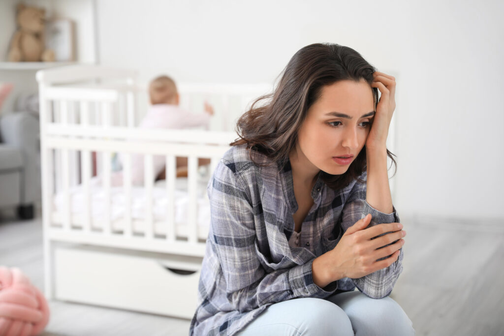 Young woman suffering from postnatal depression at home