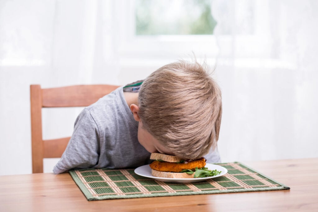 Boy landing face in food