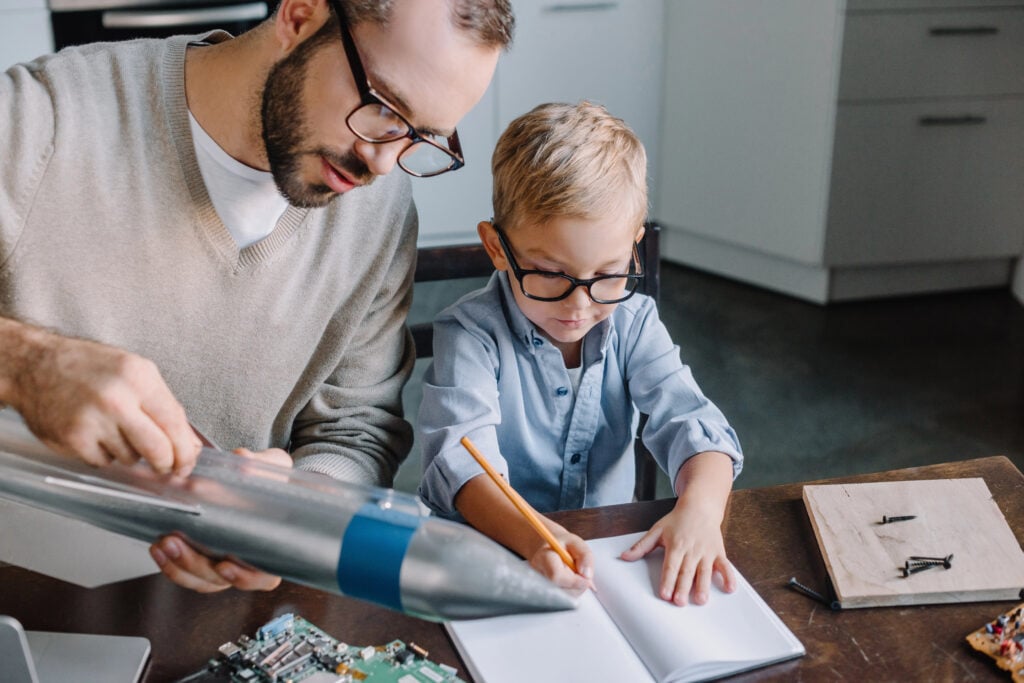 father and son testing rocket model at home