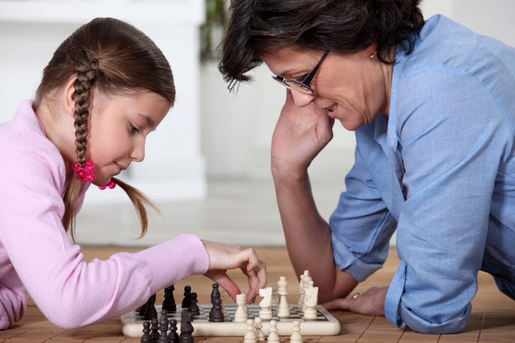 child parent playing chess