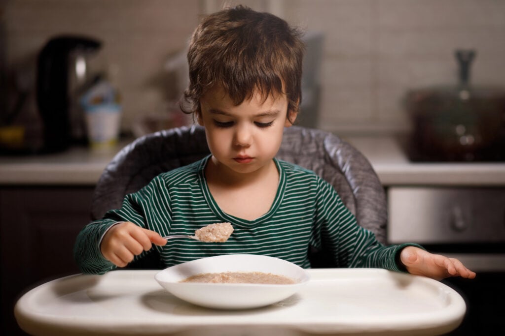 little boy with autism eats porridge