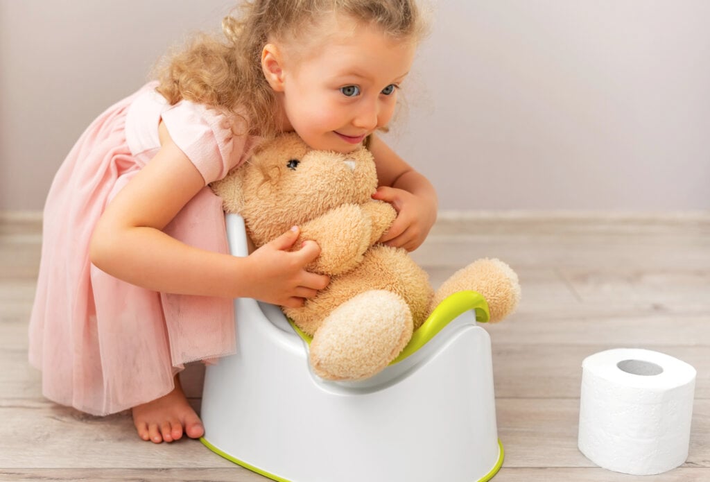 The child teaches the toy how to use the potty.