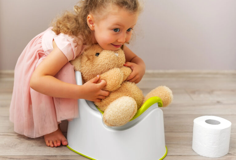 The child teaches the toy how to use the potty.