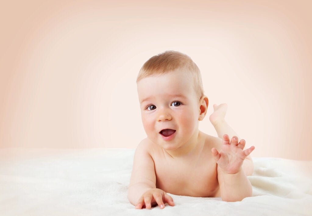 Baby lying on soft blanket at home