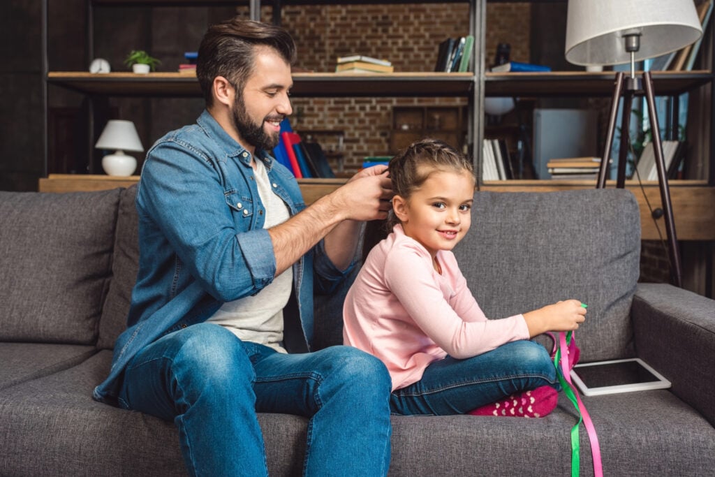 father making hair braid for daughter