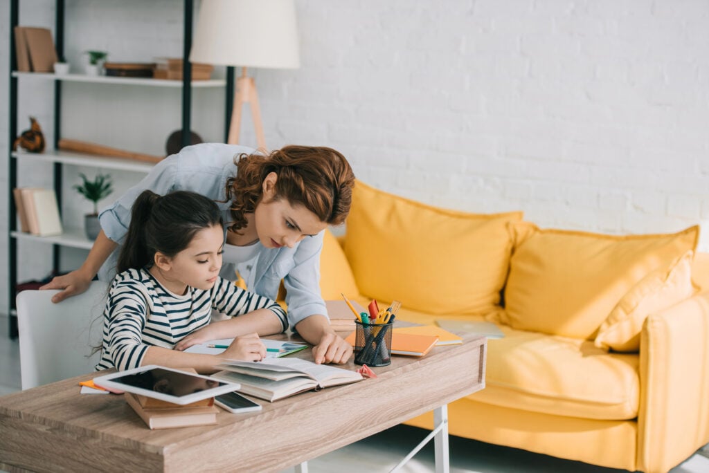 mom helping daughter with schoolwork