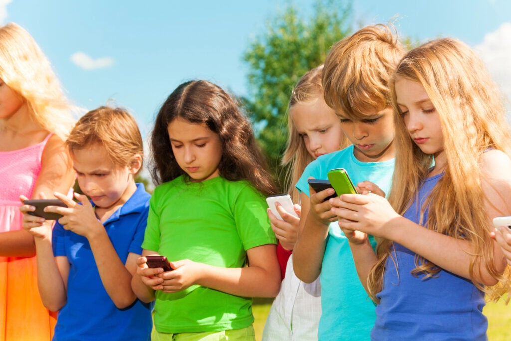 Group of kids on their phones.