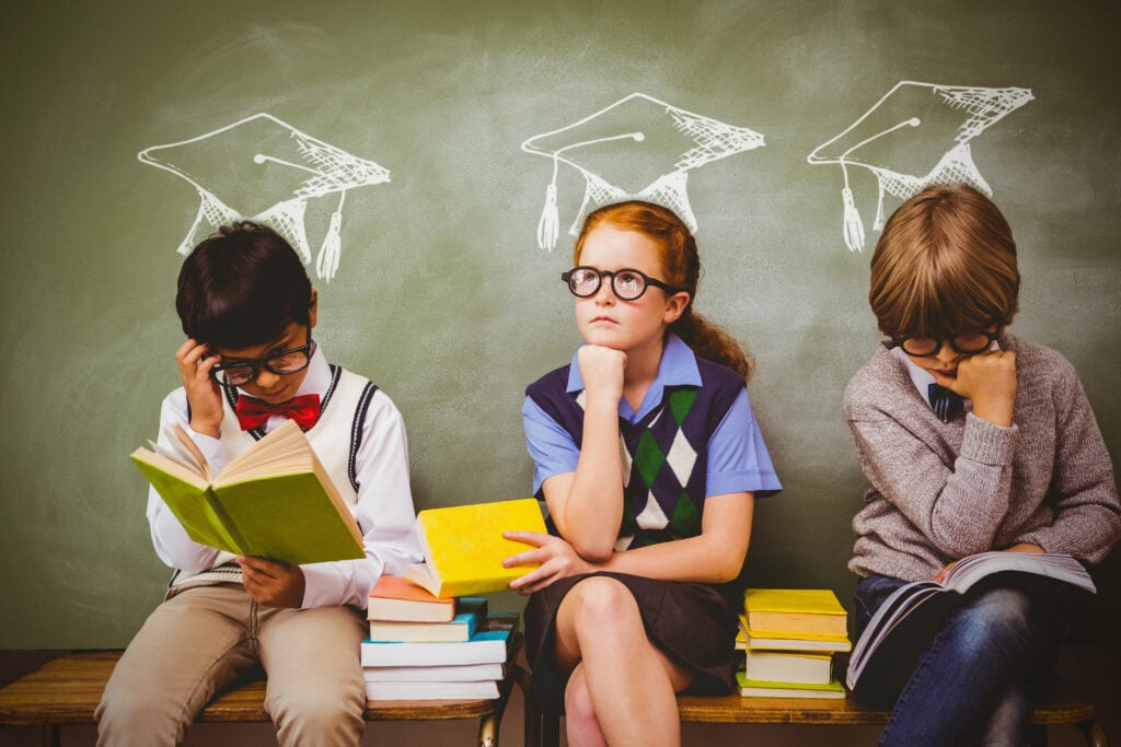 kids with stack of books in classroom