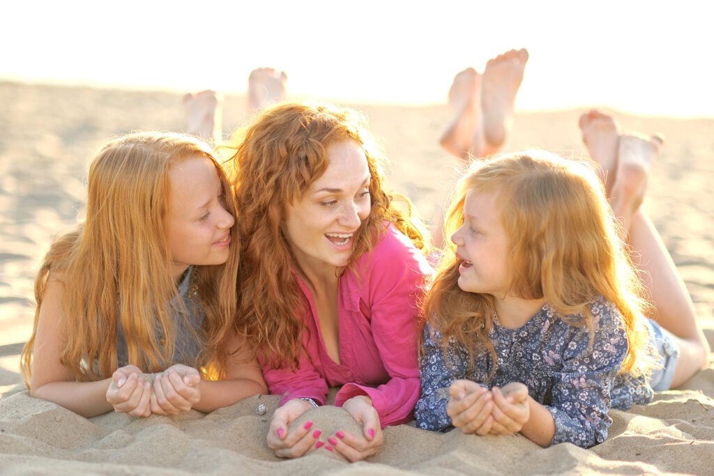 mother and her two daughters on the beach in summer