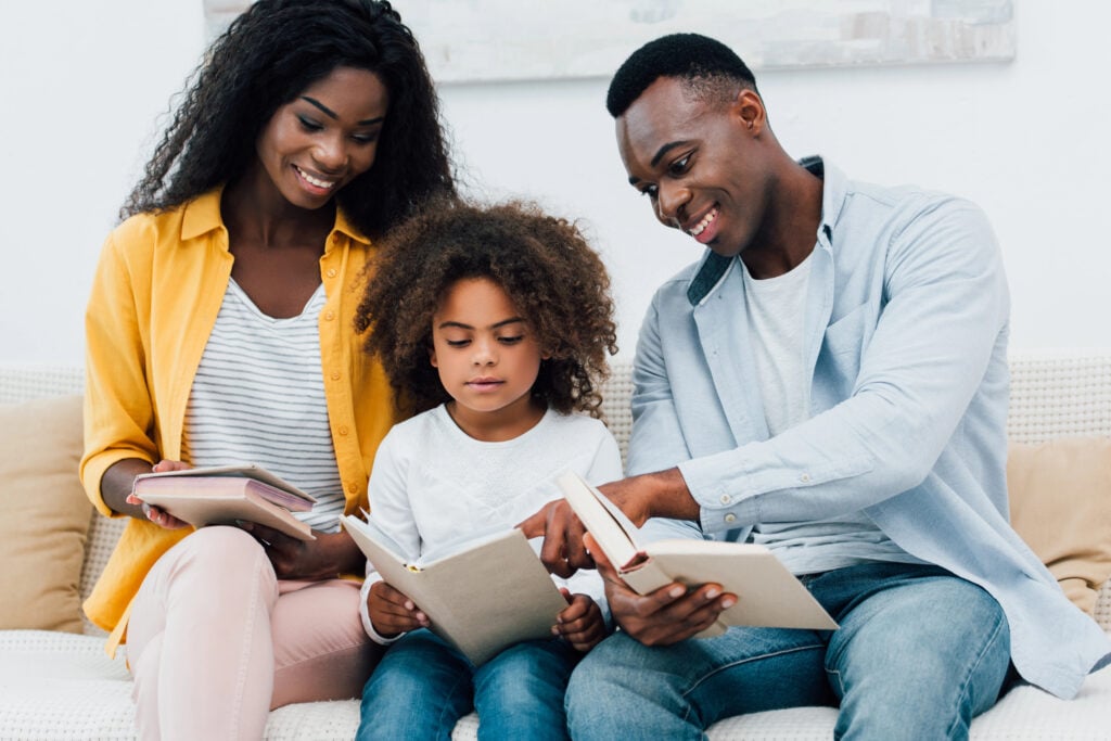 african american parents and kid looking at book
