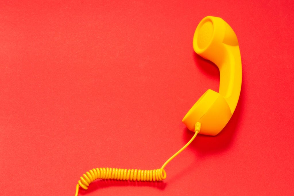 Yellow handset on red background.